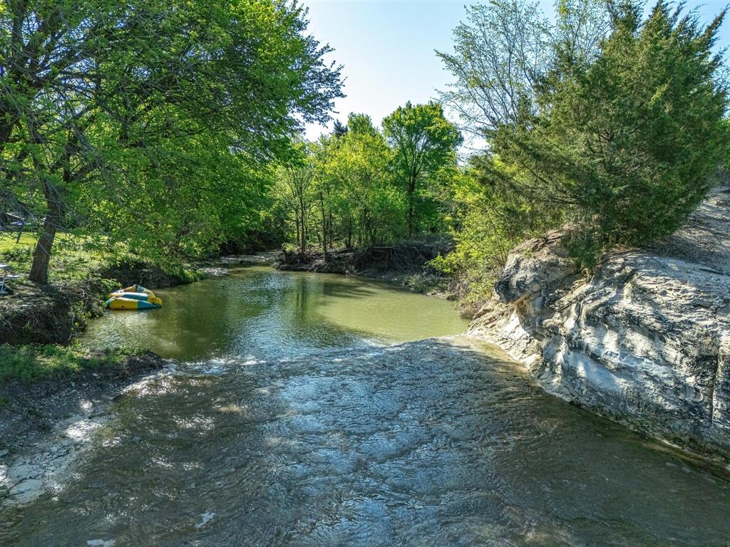 1302 Forreston Road Waxahachie, TX 75165 - Photo 2 of 39 a view of a water pond with green yard