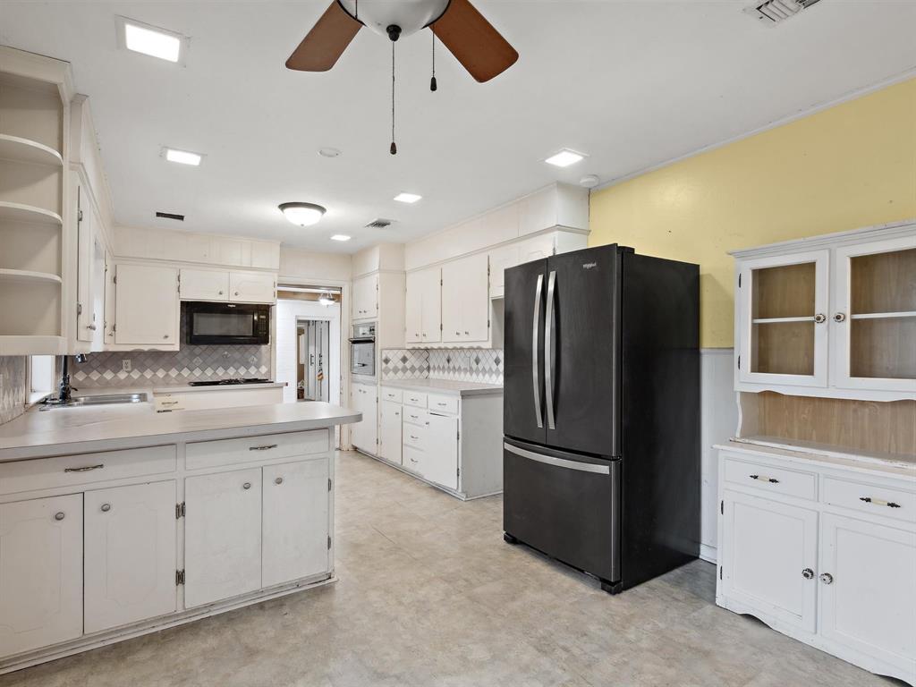 1302 Forreston Road Waxahachie, TX 75165 - Photo 24 of 39 a kitchen with stainless steel appliances a refrigerator sink and cabinets