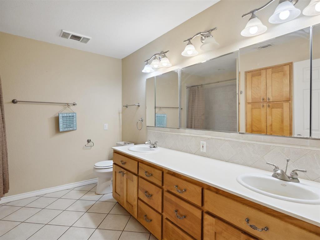 1302 Forreston Road Waxahachie, TX 75165 - Photo 33 of 39 a spacious bathroom with a granite countertop sink mirror and toilet