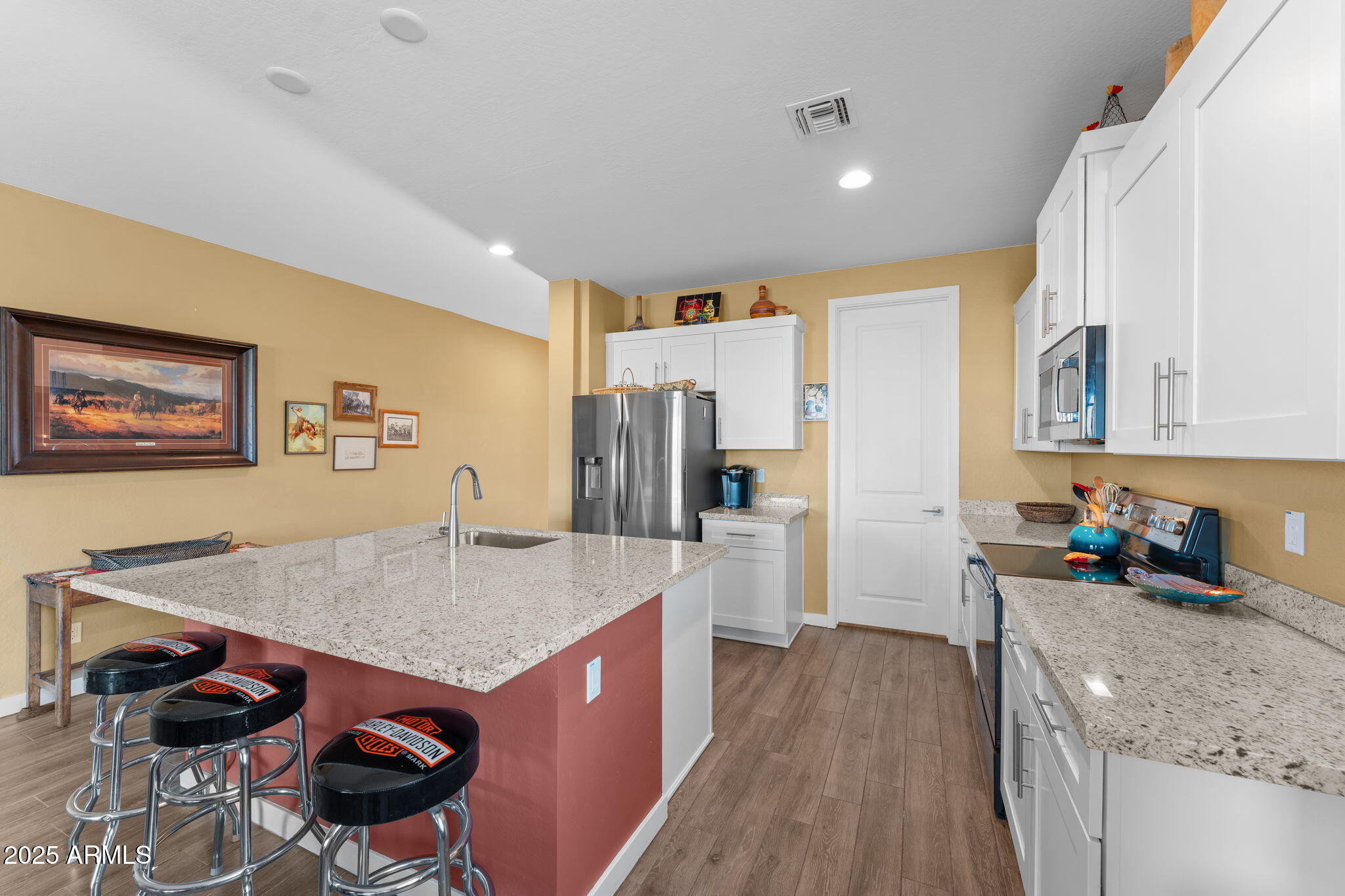 1900 West Ringo Road Wickenburg, AZ 85390 - Photo 11 of 37 a kitchen with stainless steel appliances granite countertop a sink dishwasher stove and refrigerator with wooden floor