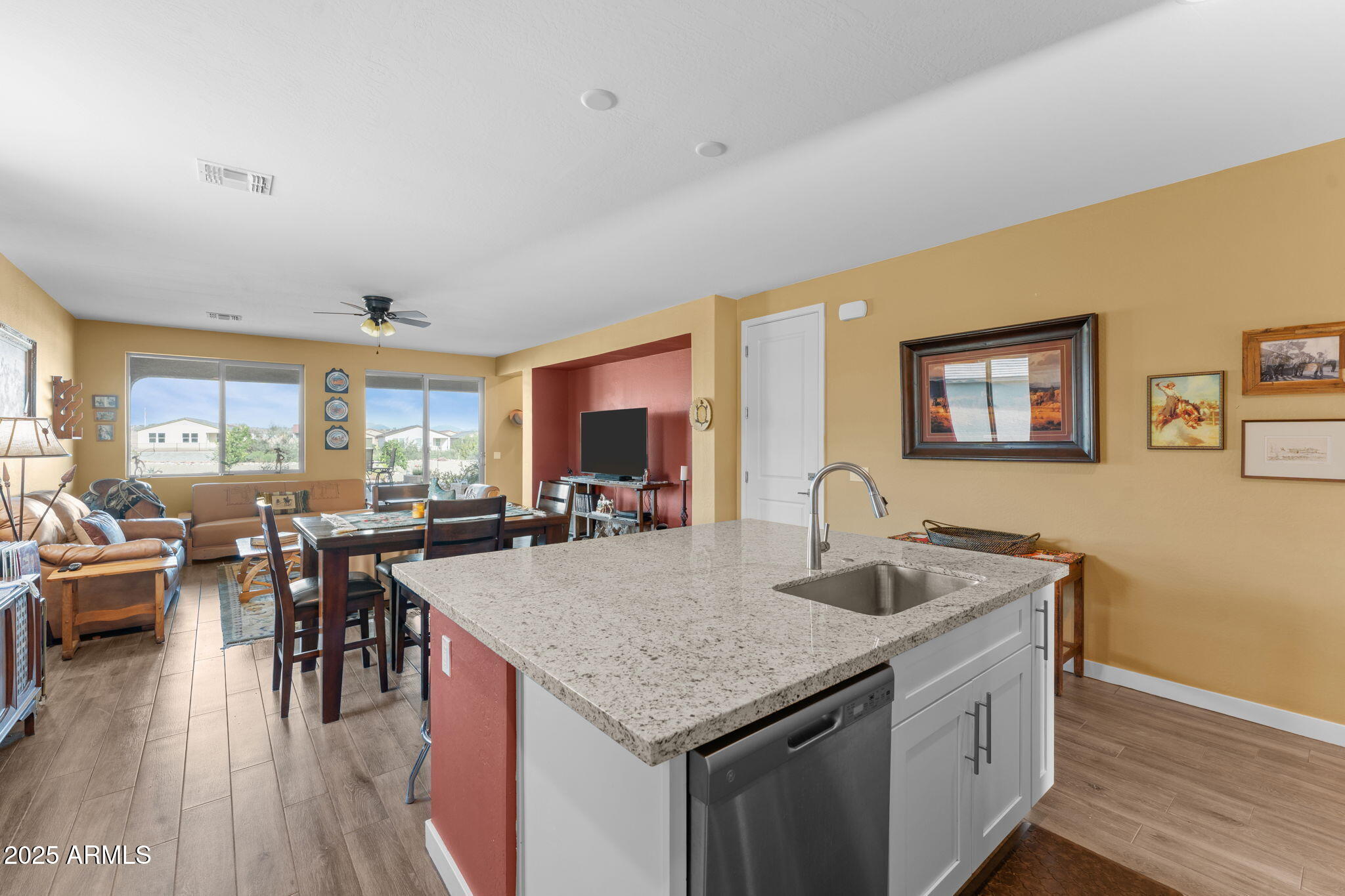 1900 West Ringo Road Wickenburg, AZ 85390 - Photo 13 of 37 a kitchen with granite countertop a table chairs sink and wooden floor