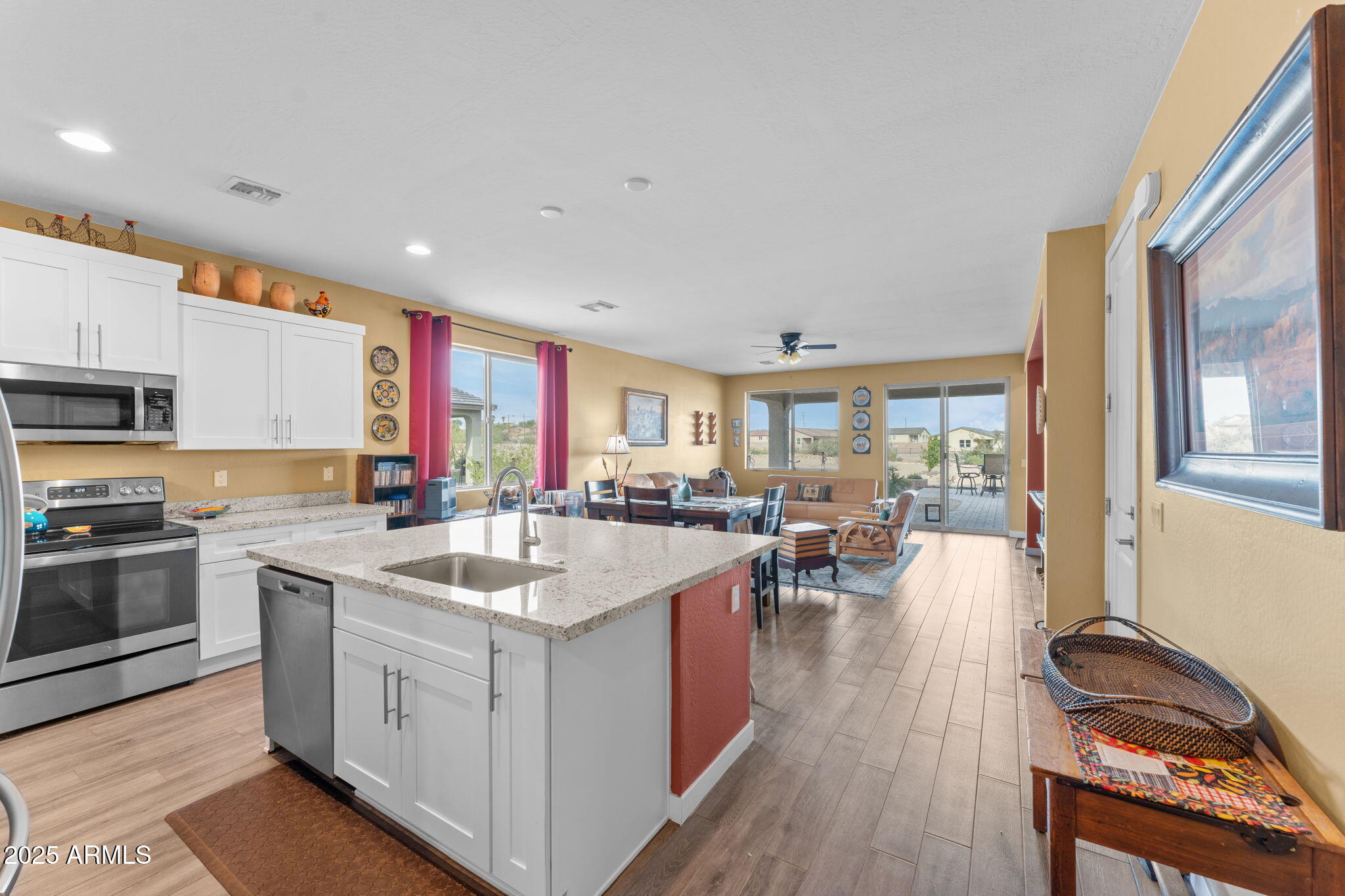 1900 West Ringo Road Wickenburg, AZ 85390 - Photo 3 of 37 a kitchen with a sink stove and wooden cabinets