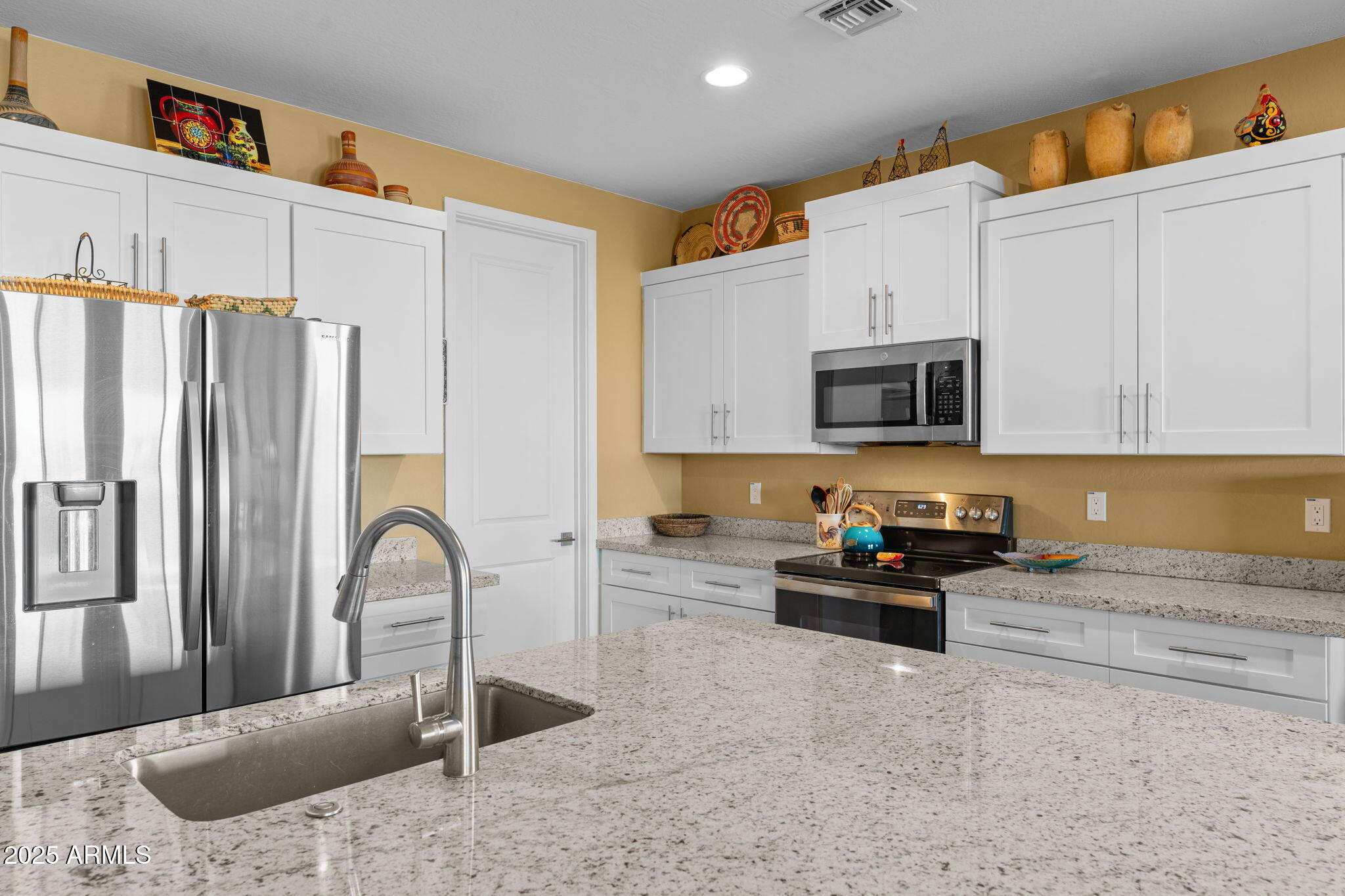 1900 West Ringo Road Wickenburg, AZ 85390 - Photo 10 of 37 a kitchen with stainless steel appliances granite countertop a stove a sink and a refrigerator