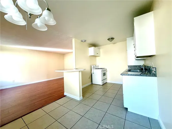 a kitchen with a sink a stove top oven and cabinets