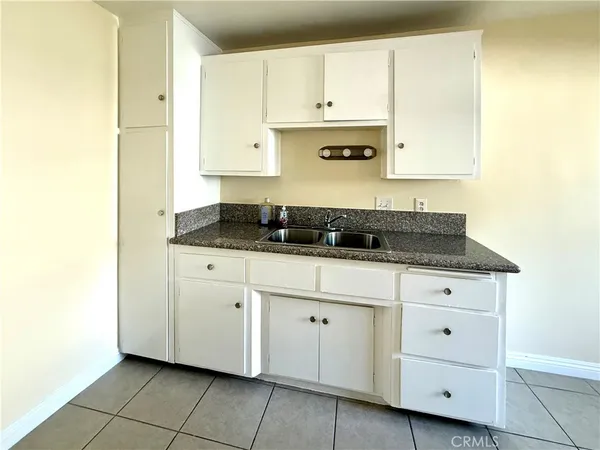 a kitchen with granite countertop white cabinets and stainless steel appliances