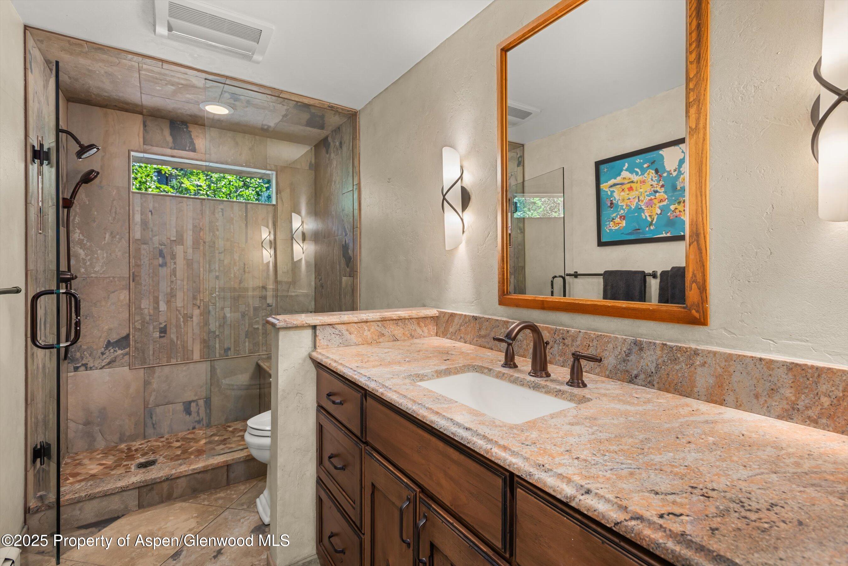 49 Elk Ridge Lane Snowmass Village, CO 81615 - Photo 28 of 38 a bathroom with a granite countertop sink mirror and shower