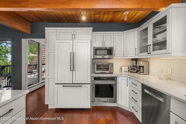 a dining room with furniture a chandelier and wooden floor