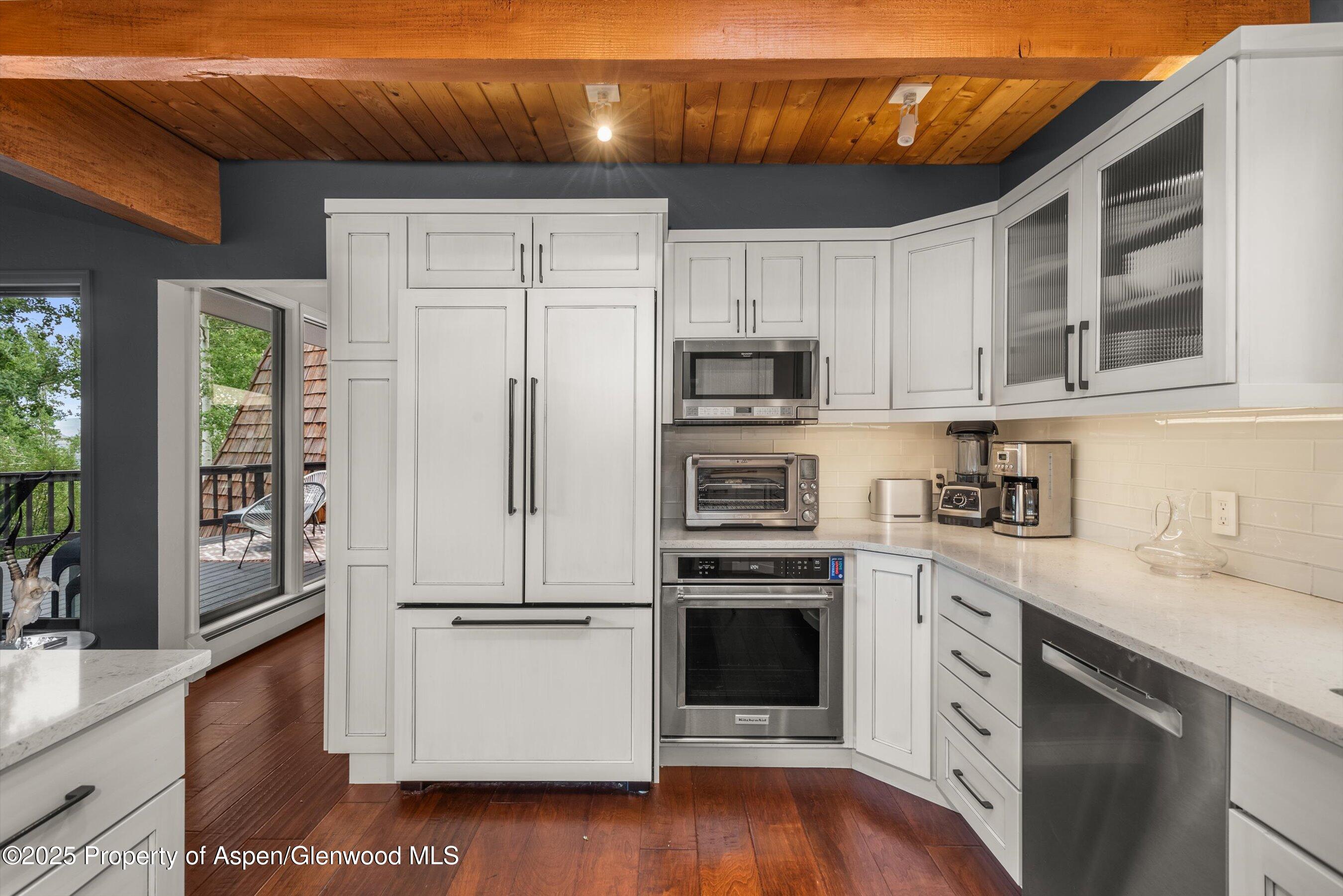49 Elk Ridge Lane Snowmass Village, CO 81615 - Photo 9 of 38 a kitchen with kitchen island granite countertop a stove top oven a sink a counter space and cabinets