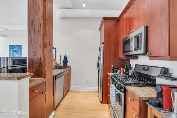 a kitchen with stainless steel appliances granite countertop a stove and a refrigerator