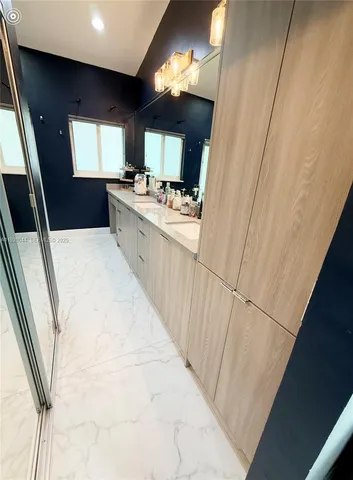 a large white kitchen with sink and washing machine