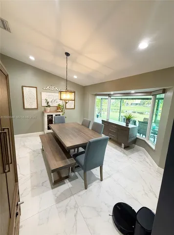 a living room with furniture a rug and a floor to ceiling window
