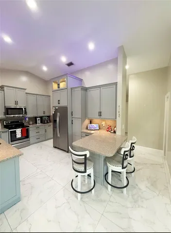 a room with stainless steel appliances lots of counter space furniture and kitchen view