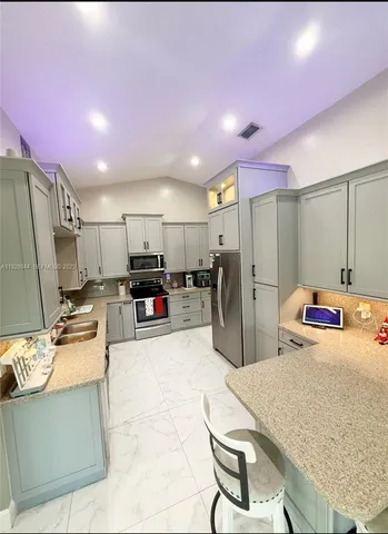 a kitchen with refrigerator and cabinets