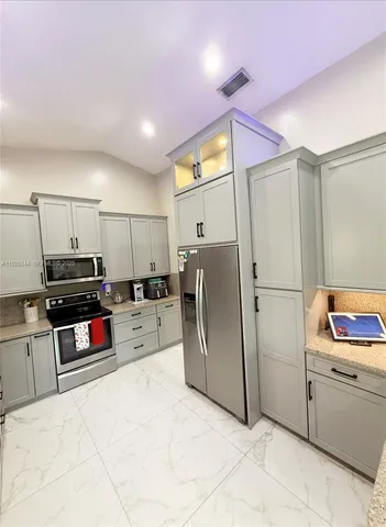a large kitchen with stainless steel appliances granite countertop a sink and cabinets