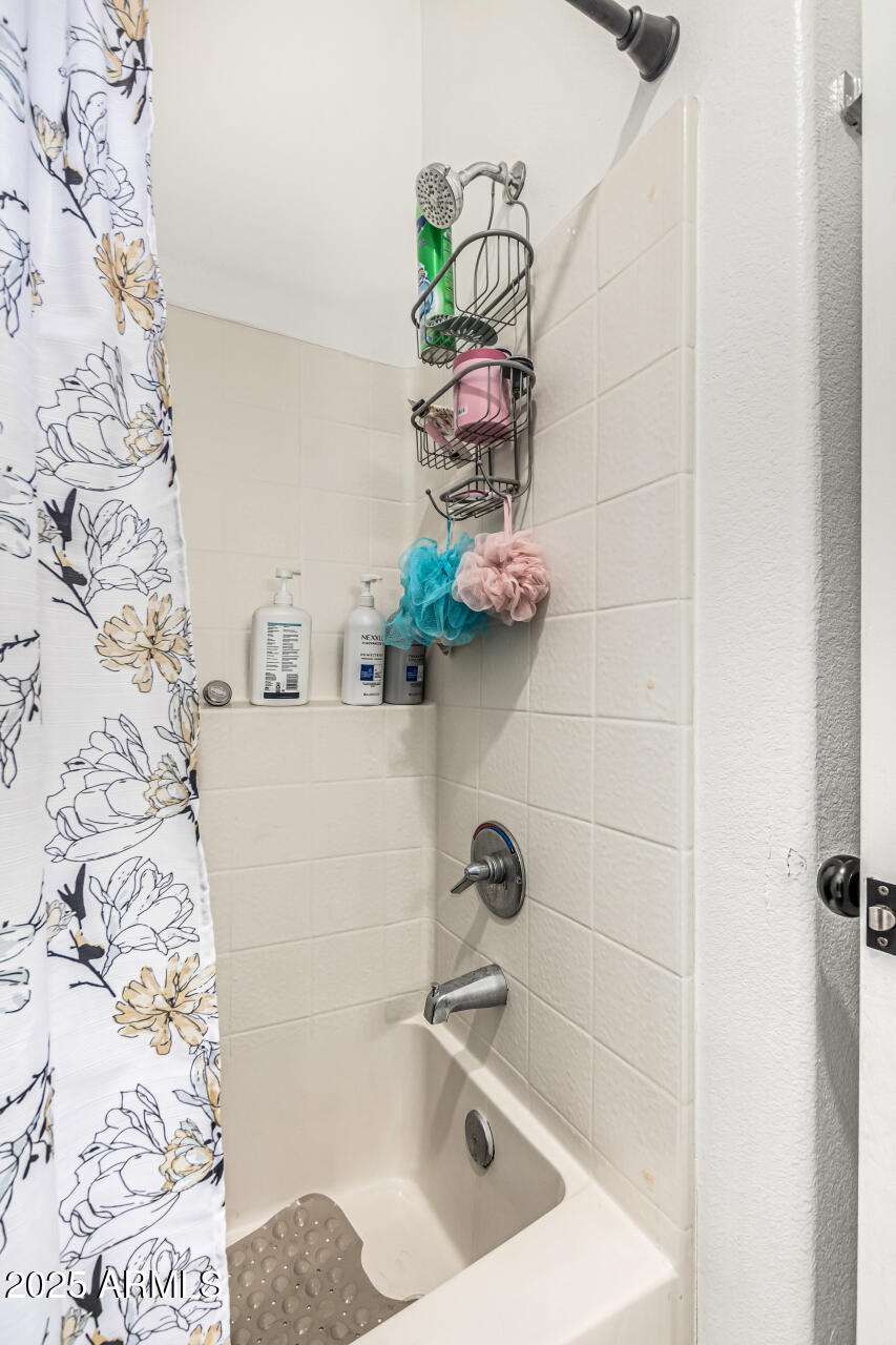 10030 West Indian School Road, Unit 255 Phoenix, AZ 85037 - Photo 16 of 27 a bathroom with a sink a mirror and tub