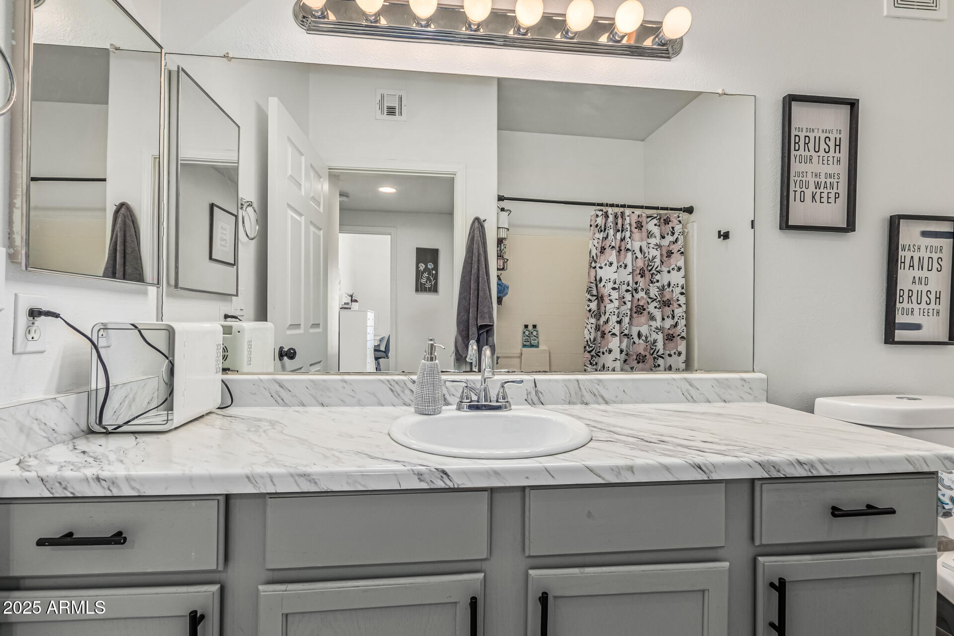 10030 West Indian School Road, Unit 255 Phoenix, AZ 85037 - Photo 20 of 27 a bathroom with a granite countertop sink and a mirror