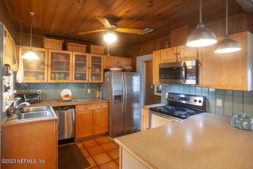 1416 Strand Street Neptune Beach, FL 32266 - Photo 11 of 27 a kitchen with stainless steel appliances granite countertop a sink a stove and a refrigerator