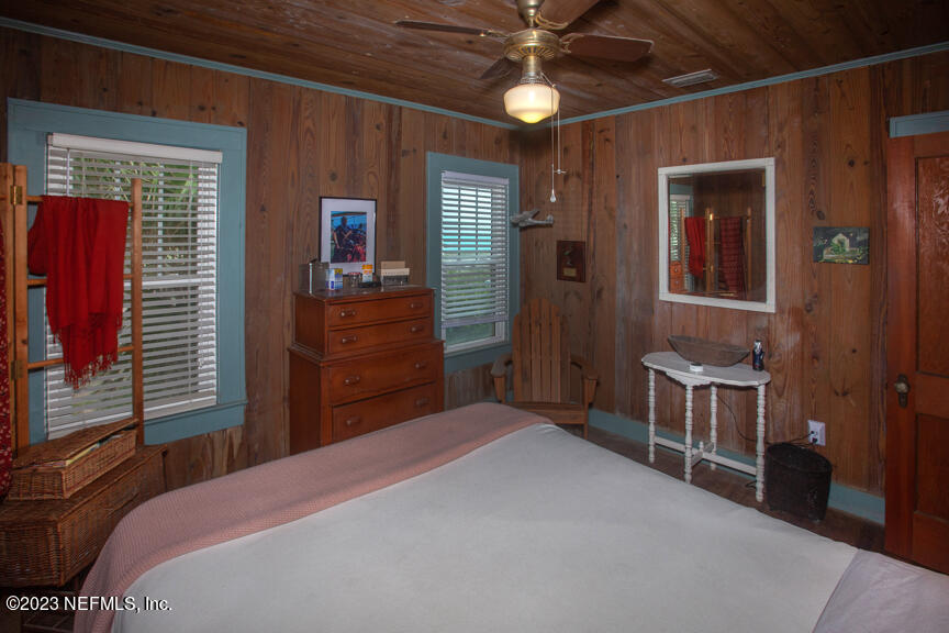 1416 Strand Street Neptune Beach, FL 32266 - Photo 21 of 27 a bedroom with a bed and a chandelier