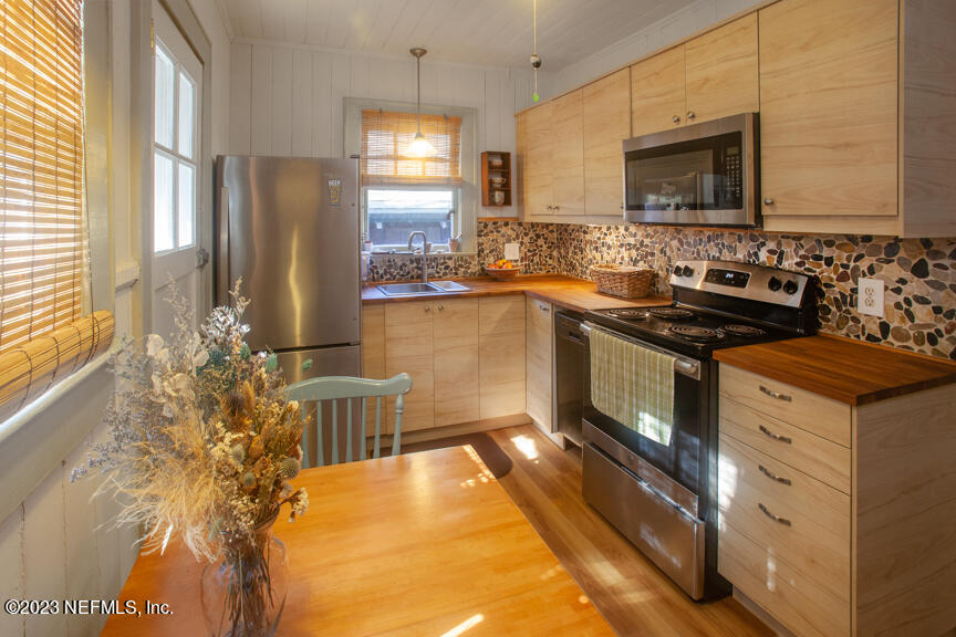 1416 Strand Street Neptune Beach, FL 32266 - Photo 4 of 27 a kitchen with stainless steel appliances granite countertop a stove a sink and a refrigerator