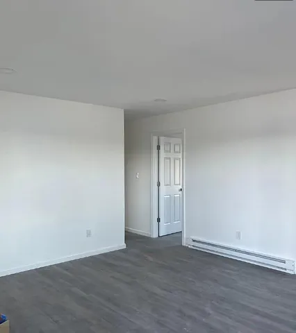 a view of an empty room and wooden floor
