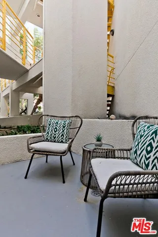 a view of a white house with a yard and potted plants