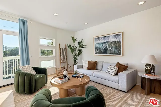 a living room with furniture potted plant and white walls