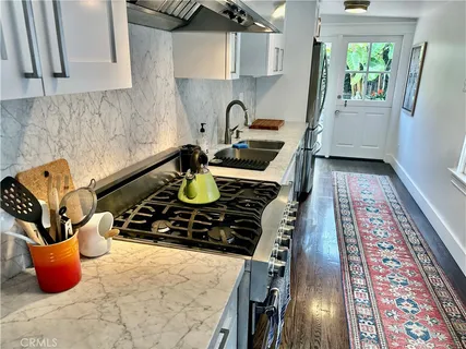 a kitchen with a stove and a wooden floor