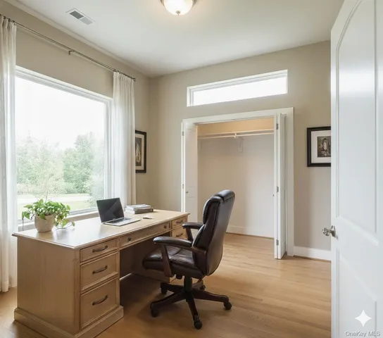 a view of a workspace with furniture and a window