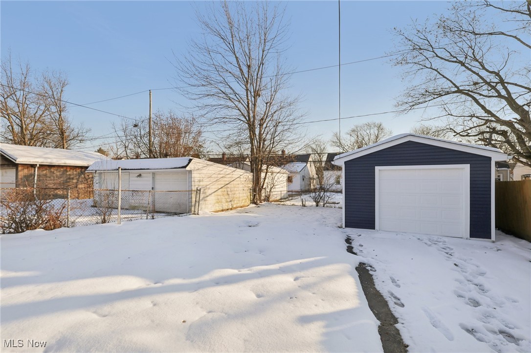 21316 Watson Road Maple Heights, OH 44137 - Photo 21 of 23 Yard covered in snow featuring an outdoor structure and a garage
