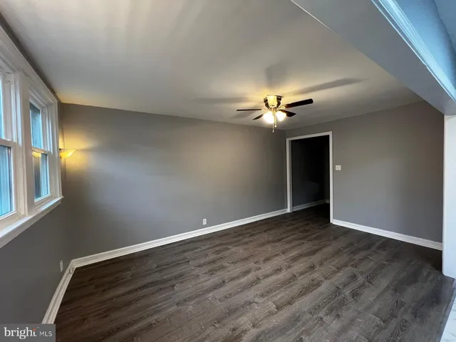 a view of an empty room with a chandelier fan