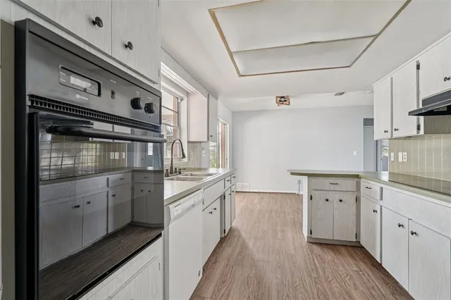 a kitchen with granite countertop cabinets stainless steel appliances and wooden floor
