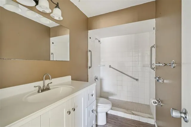 a bathroom with a sink a toilet and shower