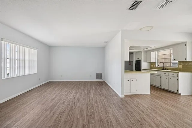 a view of kitchen with wooden floor electronic appliances and window