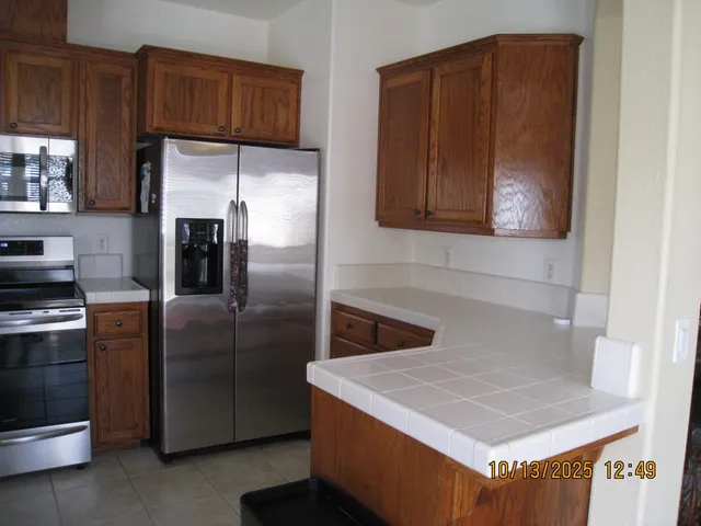 a kitchen with stainless steel appliances granite countertop a refrigerator and a stove