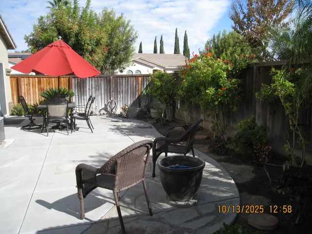 a view of patio with chairs and tables with potted plants