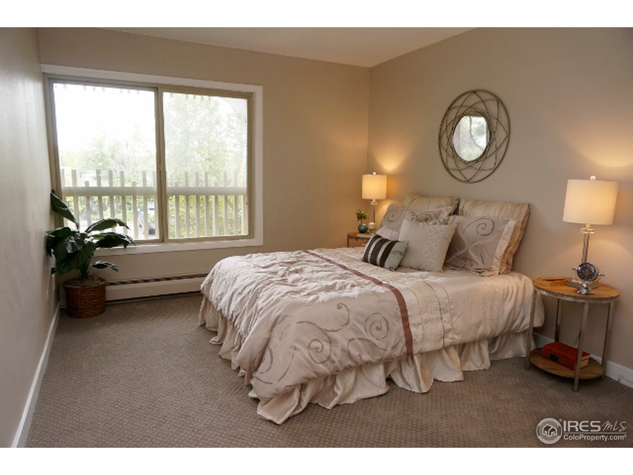 2707 Valmont Road, Unit 210D Boulder, CO 80304 - Photo 9 of 13 a bedroom with a bed mirror and a large window