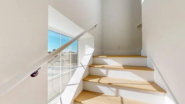 a kitchen with a sink stove and white cabinets with wooden floor