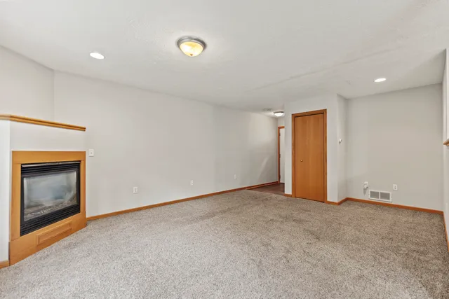 an empty room with a fireplace and window