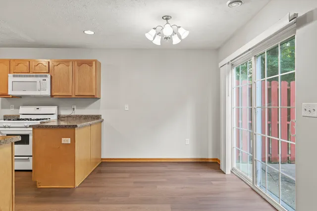 a kitchen with kitchen island granite countertop a sink cabinets and wooden floor