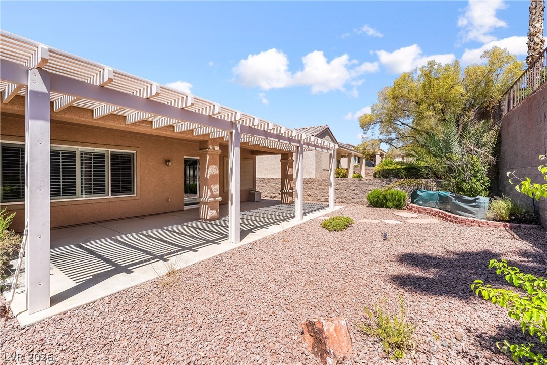 3033 Hartsville Road Henderson, NV 89052 - Photo 41 of 41 A private backyard oasis features a spacious covered patio, perfect for outdoor relaxation.