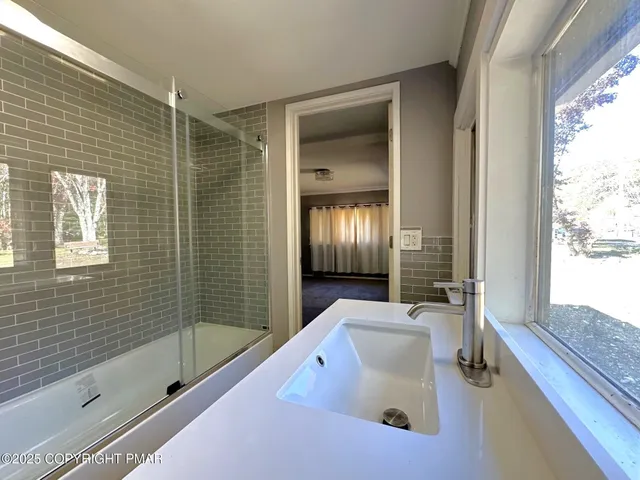 a bathroom with a tub sink and mirror