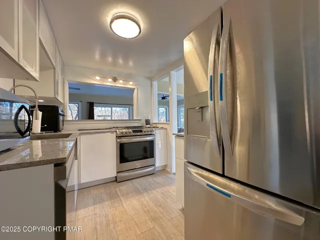 a kitchen with stainless steel appliances a refrigerator sink and cabinets