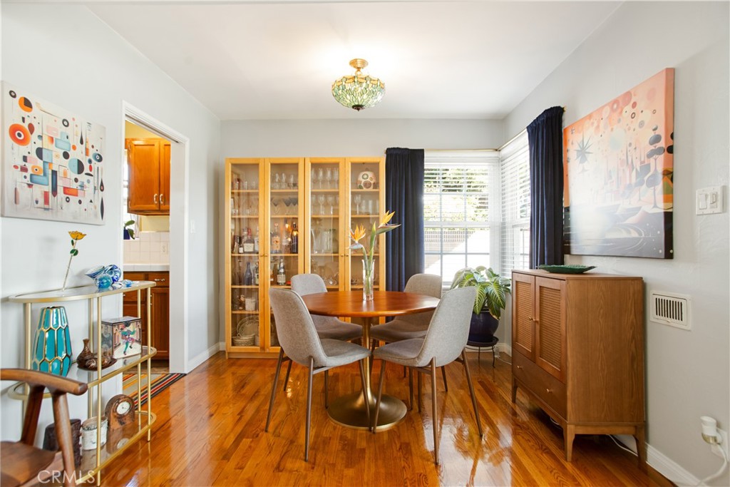 9253 Rose Street Bellflower, CA 90706 - Photo 11 of 36 a view of a dining room with furniture a chandelier and wooden floor