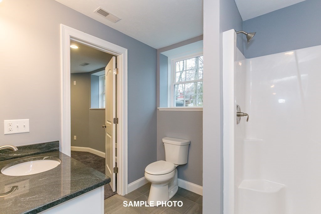 687 Boston Road Billerica, MA 01821 - Photo 17 of 20 a bathroom with a granite countertop toilet a sink and a mirror