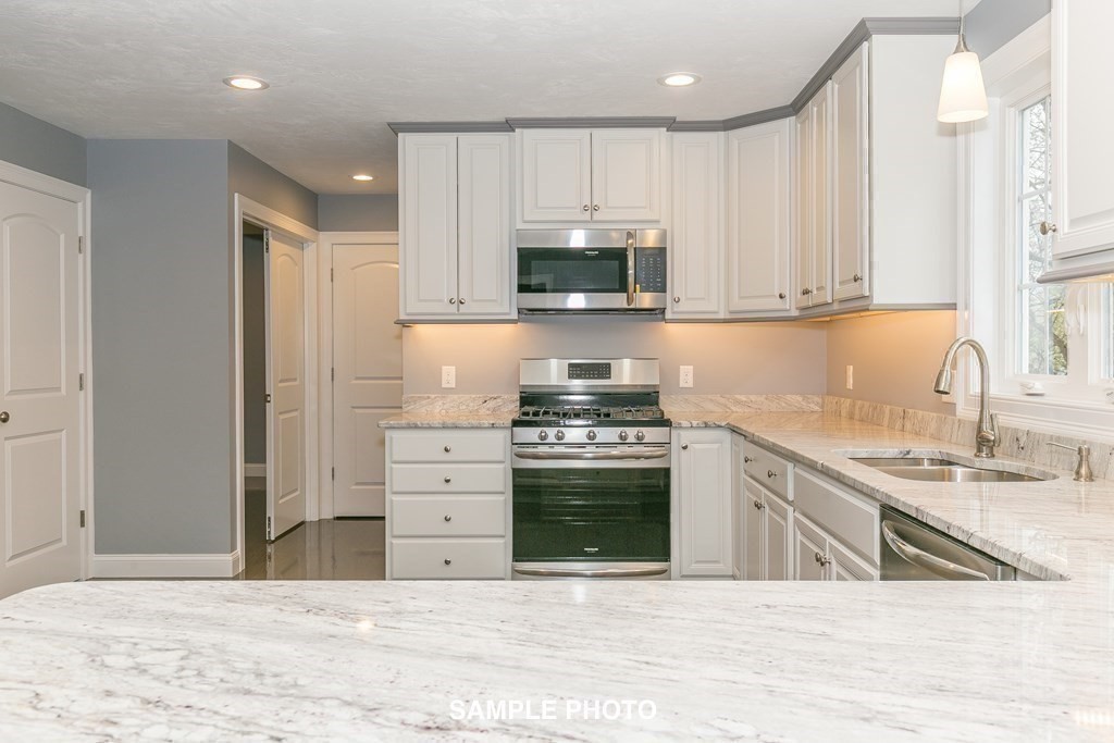 687 Boston Road Billerica, MA 01821 - Photo 8 of 20 a kitchen with stainless steel appliances granite countertop a stove a sink and a refrigerator