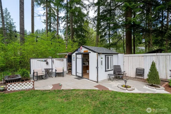 a view of a chair and table in backyard of the house