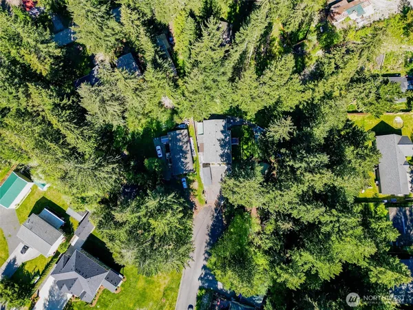 an aerial view of residential house with outdoor space and trees all around