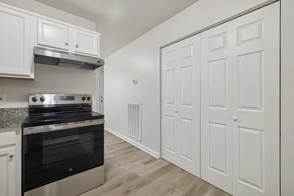 a view of an empty room with wooden floor