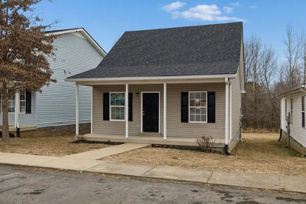 a view of empty room with wooden floor and window