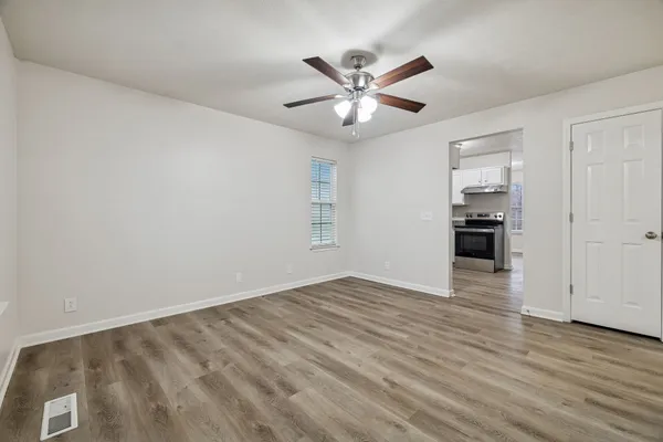 an empty room with wooden floor and windows